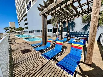 a group of beach chairs sitting on a deck next to a pool at Ocean Reef Beach Resort! Beach Front! Free Seasonal Beach Chairs! by Dolce Vita Getaways PCB in Panama City Beach