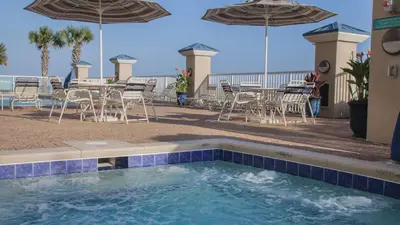 a swimming pool with chairs and tables and umbrellas at Holiday Inn Club Vacations Panama City Beach Resort in Panama City Beach