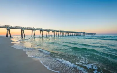 a pier stretches out over the ocean at sunset at Holiday Inn Club Vacations Panama City Beach Resort in Panama City Beach