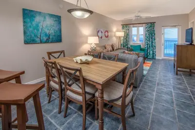 a dining room and living room with a table and chairs at Holiday Inn Club Vacations Panama City Beach Resort in Panama City Beach