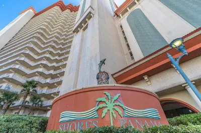 a building with a sign in front of a hotel at Shores of Panama Condo With Same Level Parking in Panama City Beach