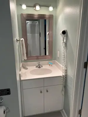 a bathroom with a sink and a mirror at Shores of Panama Condo With Same Level Parking in Panama City Beach