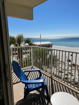 a blue chair sitting on a balcony overlooking the beach at Shores of Panama Condo With Same Level Parking in Panama City Beach