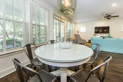 a dining room with a white table and chairs at Anchors Up in Watersound Beach