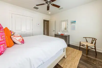 a bedroom with a white bed and a ceiling fan at Anchors Up in Watersound Beach