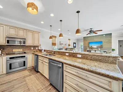 a large kitchen with wooden cabinets and stainless steel appliances at Aweigh From Home in Santa Rosa Beach