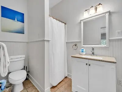 a white bathroom with a toilet and a sink at Aweigh From Home in Santa Rosa Beach
