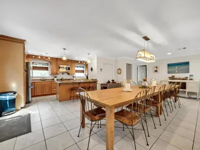a kitchen and dining room with a wooden table and chairs at Aweigh From Home in Santa Rosa Beach