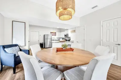 a kitchen and dining room with a wooden table and chairs at Palm Grove at Sago Sands Unit A in Seagrove Beach
