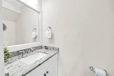 a white bathroom with a sink and a mirror at Palm Grove at Sago Sands Unit A in Seagrove Beach