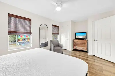 a white bedroom with a bed and a television at Palm Grove at Sago Sands Unit A in Seagrove Beach
