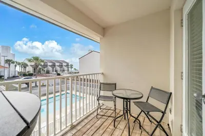 a balcony with a table and chairs and a pool at Palm Grove at Sago Sands Unit A in Seagrove Beach