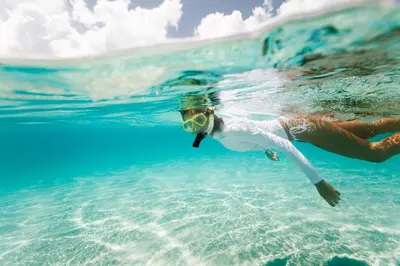 a woman swimming in the water in the ocean at Coastal Blue 141 in Seagrove Beach