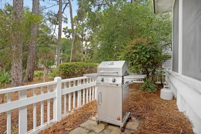 a grill sitting on a porch next to a fence at Captain's Cottage in Watersound Beach