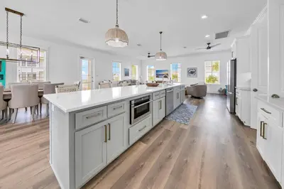 a kitchen with white cabinets and a large kitchen island at Kiwi Grove in Seagrove Beach