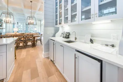 a kitchen with white cabinets and a dining room at The Nautilus in Watersound Beach