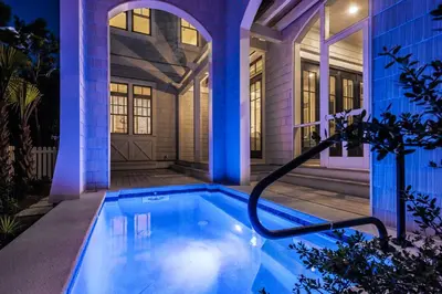 a swimming pool in front of a house at night at The Nautilus in Watersound Beach