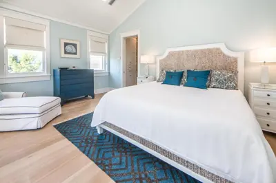a bedroom with a large white bed with blue pillows at The Nautilus in Watersound Beach