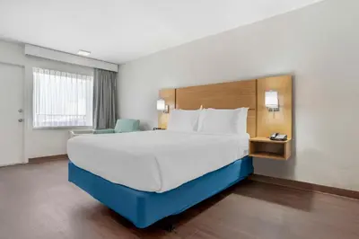 a hotel room with a large bed and a chair at Chateau Beachfront Hotel, a By the Sea Resort in Panama City Beach