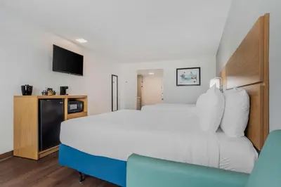 a hotel room with a large bed and a tv at Chateau Beachfront Hotel, a By the Sea Resort in Panama City Beach