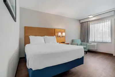 a hotel room with a large bed and a chair at Chateau Beachfront Hotel, a By the Sea Resort in Panama City Beach