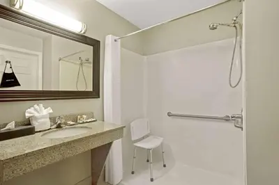 a bathroom with a sink and a shower with a mirror at La Quinta by Wyndham PCB Coastal Palms in Panama City Beach