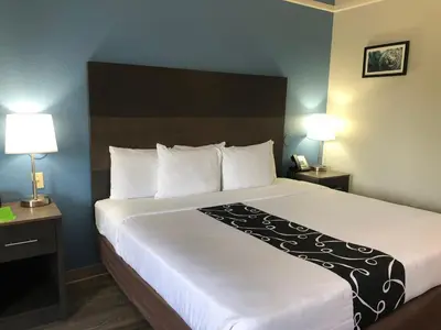 a large bed in a hotel room with two lamps at La Quinta by Wyndham PCB Coastal Palms in Panama City Beach