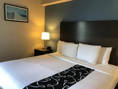 a hotel room with a large bed with white sheets at La Quinta by Wyndham PCB Coastal Palms in Panama City Beach