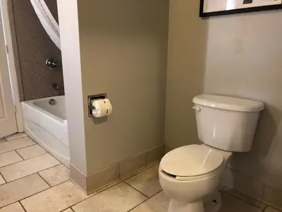 a bathroom with a toilet and a bath tub at La Quinta by Wyndham PCB Coastal Palms in Panama City Beach