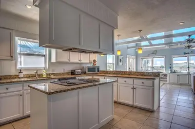a large kitchen with white cabinets and a counter top at Sun and Sand in Inlet Beach