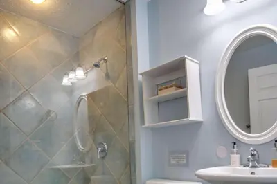 a bathroom with a shower and a sink and a mirror at Sun and Sand in Inlet Beach