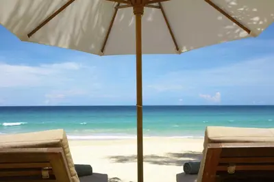 a beach with two chairs and an umbrella at Sun and Sand in Inlet Beach