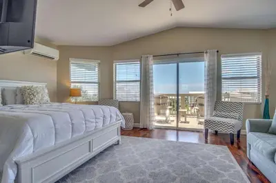a bedroom with a large bed and a balcony at Blue Sails in Inlet Beach