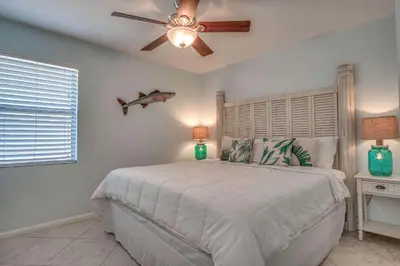 a bedroom with a bed with a ceiling fan at Blue Sails in Inlet Beach