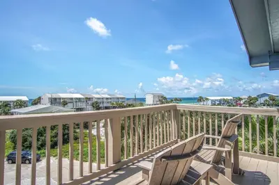 a balcony with two chairs and a view of the ocean at Blue Sails in Inlet Beach