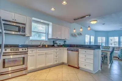 a large kitchen with white cabinets and a counter top at Blue Sails in Inlet Beach