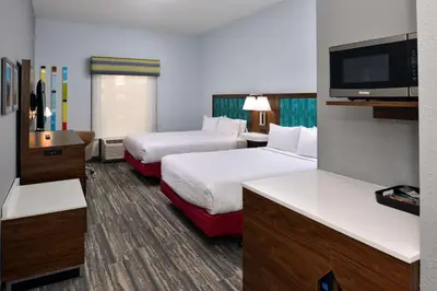 a hotel room with two beds and a flat screen tv at Hampton Inn by Hilton Panama City Beach in Panama City Beach