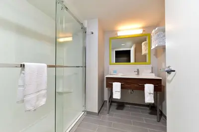a bathroom with a glass shower and a sink at Hampton Inn by Hilton Panama City Beach in Panama City Beach