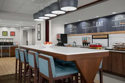 a kitchen with a large island with blue chairs at Hampton Inn by Hilton Panama City Beach in Panama City Beach