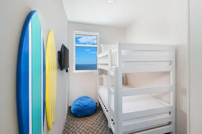 a bunk room with a bunk bed and a surfboard at SpringHill Suites by Marriott Panama City Beach Beachfront in Panama City Beach