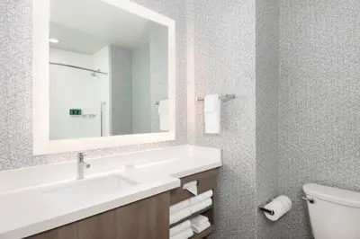 a bathroom with a sink and a mirror at SpringHill Suites by Marriott Panama City Beach Beachfront in Panama City Beach