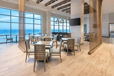 a restaurant with tables and chairs and a view of the ocean at SpringHill Suites by Marriott Panama City Beach Beachfront in Panama City Beach