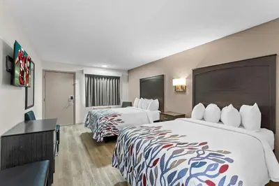 a hotel room with two beds and a desk at Red Roof Inn Panama City Beach in Panama City Beach