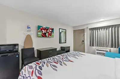 a hotel room with a large bed and a desk at Red Roof Inn Panama City Beach in Panama City Beach