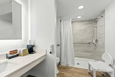 a white bathroom with a shower and a toilet at Red Roof Inn Panama City Beach in Panama City Beach