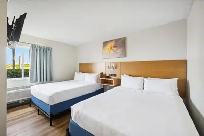 a hotel room with two beds and a window at Sugar Sands Beachfront Hotel, a By The Sea Resort in Panama City Beach