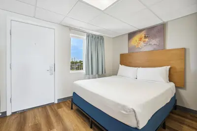a bedroom with a large bed with a large window at Sugar Sands Beachfront Hotel, a By The Sea Resort in Panama City Beach