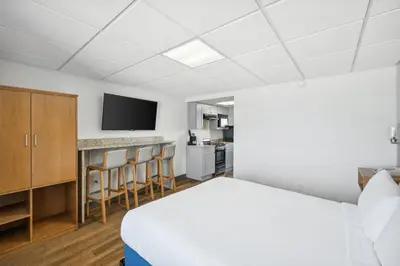 a hotel room with a bed and a kitchen at Sugar Sands Beachfront Hotel, a By The Sea Resort in Panama City Beach