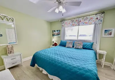 a bedroom with a blue bed and a window at Summer House 101 A in Panama City Beach