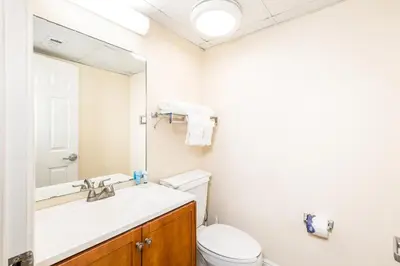 a bathroom with a sink and a toilet and a mirror at Landmark Holiday Beach in Panama City Beach